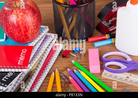 Primo piano di un assortimento di scuola e di forniture per ufficio su un tavolo di legno Foto Stock