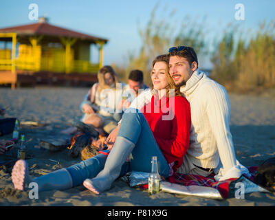 Ritratto di giovane coppia avendo divertimento sulla spiaggia durante la stagione autunnale giornata di sole Foto Stock