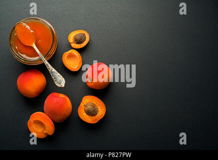 Confettura di albicocche in una ciotola di vetro con frutta intorno Foto Stock