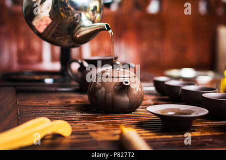 Donna tradizionalmente preparando il tè cinese in una tradizionale cerimonia del tè Foto Stock