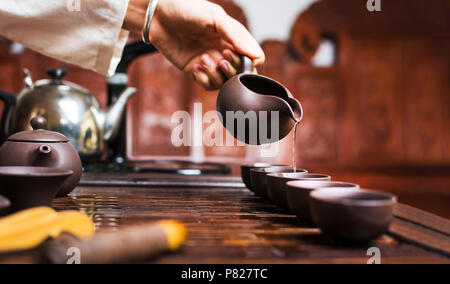 Cerimonia del tè cinese, Donna versando tradizionalmente preparato tè Foto Stock