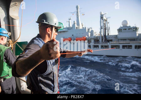 Mar Rosso (1 aprile 2016) Boatswain compagno del 3° di classe Jorge Medina heaves un shotline da bordo l'assalto anfibio nave USS Kearsarge (LHD 3) durante un rifornimento in mare con il Royal Fleet Auxiliary (RFA) nave Fort Victoria (A387). Kearsarge è l'ammiraglia per il Kearsarge Amphibious Ready Group (ARG) e, con l'avviato 26 Marine Expeditionary Unit (MEU), è distribuito come supporto di le operazioni di sicurezza marittima e di teatro la cooperazione in materia di sicurezza gli sforzi negli Stati Uniti Quinta Flotta area di operazioni. Foto Stock