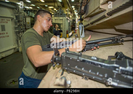 Golfo di Aden (18 aprile 2016) lancia Cpl. Paolo Ferreti esegue le operazioni di manutenzione sulle armi di piccolo calibro dei monti di un M1A1 Abrams serbatoio posizionato nel pozzetto mazzo di dock landing ship USS harpers Ferry (LSD 49). Harpers Ferry è parte del Boxer anfibio gruppo pronto e, con l'avviato xiii Marine Expeditionary Unit, è distribuito come supporto di le operazioni di sicurezza marittima e di teatro la cooperazione in materia di sicurezza gli sforzi negli Stati Uniti Quinta Flotta area di operazioni. Foto Stock