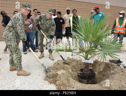 Supporto navale attività BAHRAIN (20 aprile 2016) -- Capt. Cory Howes, comandante navale attività di supporto Bahrain (NSA), centro e Cmdr. Steven Williams, dirigente della NSA, sinistra, piantare un albero in osservazione della Giornata della Terra. NSA Bahrain consente il funzionamento in marcia avanti e la velocità di risposta degli Stati Uniti e delle forze alleate a sostegno del Navy regione Europa, Africa, Asia sud-ovest (EURAFSWA) missione di fornire i servizi per la flotta, Fighter, e famiglia. Foto Stock