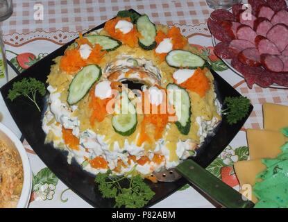 Insalata steso su un piatto e decorate con le erbe aromatiche e i cetrioli. Still-life Foto Stock