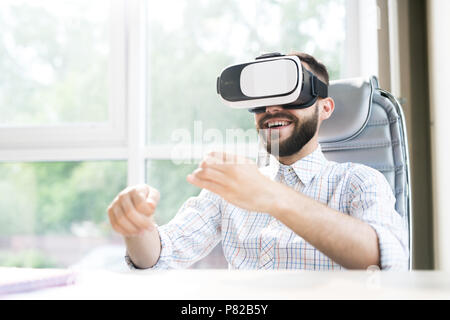 Uomo bello godersi VR in ufficio Foto Stock