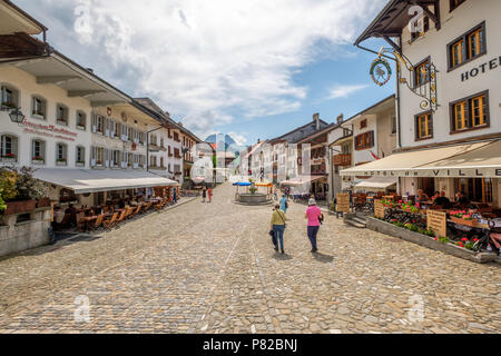 Rue de Bourg, la strada medievale fino al Gruyeres Casltle. Ristoranti e felici le persone. Foto Stock