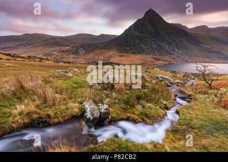 Un flusso nel Parco Nazionale di Snowdonia con Tryfan nella distanza. Foto Stock