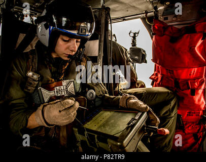 Mare delle Filippine (26 giugno 2016) Ospedale Corpsman terza classe (NAC/AW) Emily Honan, assegnato al 'Golden falchi' di elicottero di mare squadrone di combattimento (HSC) 12, da Biggs, California, utilizza una mappa digitale cosciale per accedere a un MH-60S Sea Hawk's forward-looking telecamera a raggi infrarossi. La HSC-12 "falchi d'Oro" è uno dei 17 MH-60S Sea Hawk squadroni di servire nella marina di oggi. La USS Ronald Reagan Carrier Strike gruppo è di pattuglia NEGLI STATI UNITI 7 flotta area di responsabilità il supporto di sicurezza e stabilità nella Indo-Asia-regione del Pacifico. Foto Stock