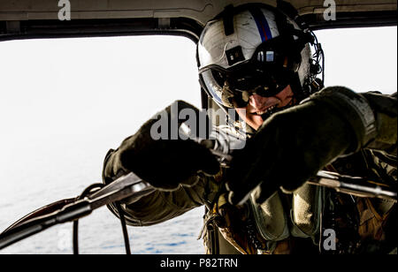 Mare delle Filippine (26 giugno 2016) Naval Air Crewman (elicottero) Seconda Classe (NAC/AW) Paolo Nutting, assegnato al 'Golden falchi' di elicottero di mare squadrone di combattimento (HSC) 12, da Springfield, Missouri, prepara un collassabile, autoraddrizzante cestello di salvataggio per una ricerca e un'esercitazione di soccorso a bordo di un MH-60S Sea Hawk. Il MH-60 Sea Hawk serve a combattere la ricerca e il salvataggio, logistica, interdizione della droga, anti-pirateria, le operazioni umanitarie di soccorso e airborne contromisure mine in aggiunta al suo anti-guerra di superficie, Naval Special Warfare e operazioni speciali funzionalità. La USS Ronal Foto Stock