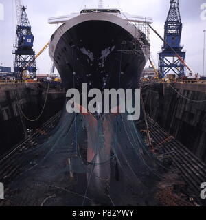 AJAXNETPHOTO. Dic 1996. SOUTHAMPTON, Inghilterra. - Vista di prua della Cunard NAVE PASSEGGERI QUEEN ELIZABETH 2 - QE2 - KGV in bacino di carenaggio, il suo scafo è avvolta nella rete, subisce riattaccare. Foto:JONATHAN EASTLAND/AJAX. REF:1296 32 Foto Stock