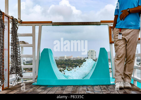 Miami, Florida - Marzo 29 2014: membro di equipaggio in piedi dalla parte superiore del scivolo a bordo della Carnival Liberty nave da crociera Foto Stock