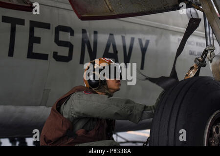 Oceano Pacifico (nov. 28, 2016) Petty Officer 2a classe Winer Fung da Oakland, la California, esegue un controllo di turnaround su un C-2un levriero dai fornitori di logistica della flotta contro lo squadrone di supporto (VRC) 30, di distacco 4, sulla USS John C. Stennis' (CVN 74) ponte di volo per garantire l'aereo ha la missione la prontezza. John C. Stennis è in corso per condurre la formazione di routine e partecipare nella legislazione nazionale in materia di Pearl Harbor giorno del ricordo di eventi nelle Hawaii. Foto Stock