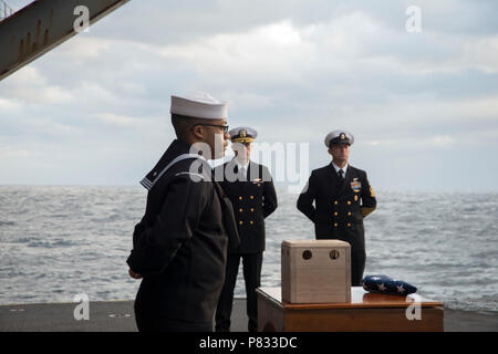 Oceano atlantico (dec. n. 3, 2016) marinai stand alla sfilata di riposo durante una sepoltura in mare cerimonia a bordo della portaerei USS George Washington (CVN 73). George Washington, homeported in Norfolk, è in corso la conduzione di qualifiche nell'Oceano Atlantico. Foto Stock