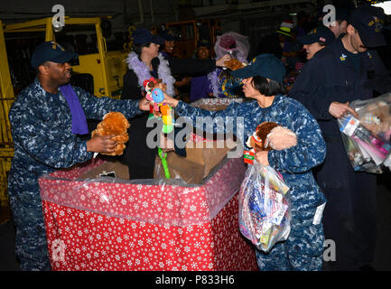 MAYPORT, Fla. (dec. n. 15, 2016) - marinai ricevere giocattoli distribuiti dal Chief Petty Officer Association, 1a classe Petty Officer Association, 2a classe Petty Officer Association e la coalizione dei marinai contro decisioni distruttive a bordo di assalto anfibio nave USS Iwo Jima (LHD 7). Iwo Jima è attualmente al suo homeport di Mayport, Fla. condurre una pianificazione di manutenzione continua disponibilità. Foto Stock