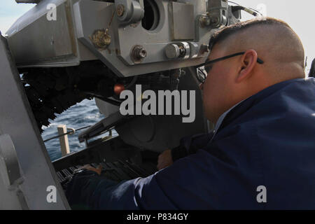 Mare Mediterraneo (feb. 18, 2017) - Da bombardieri Mate Seaman David Gonzalez, da Clinton Township, Mich, effettua la manutenzione su un MK 38 .25mm mitragliatrice a bordo della USS Donald Cook (DDG 75), feb 18, 2017. Donald Cook, un Arleigh Burke-class guidato-missile distruttore, distribuita a Rota, Spagna, sta conducendo operazioni navali negli Stati Uniti Sesta flotta area di operazioni a sostegno degli Stati Uniti per gli interessi di sicurezza nazionali in Europa e in Africa. Foto Stock