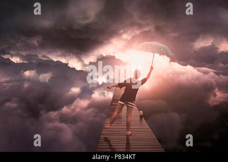 Donna con ombrello battenti nella tempesta cloud Foto Stock