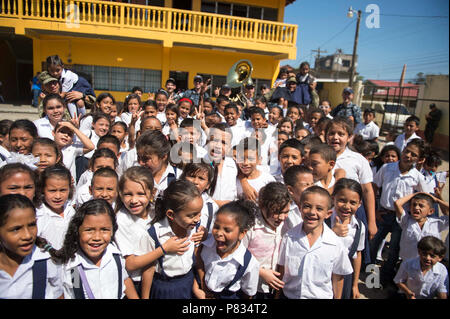 TRUJILLO, Honduras (feb. 27, 2017) - marinai posano per una foto con honduregni a scuola i bambini a seguito di una U.S. Le forze della flotta (USFF) prestazioni in banda continua di supporto promessa 2017's (CP-17) visita a Trujillo, Honduras. CP-17 è un U.S. Comando sud-sponsorizzato e U.S. Forze Navali Comando meridionale/STATI UNITI 4a flotta-condotto di distribuzione condotta civile-militare comprendente le operazioni di assistenza umanitaria, impegni di formazione e medico, dentista e supporto di veterinari in uno sforzo per mostrare il supporto degli Stati Uniti e di impegno per l'America centrale e del Sud. Foto Stock