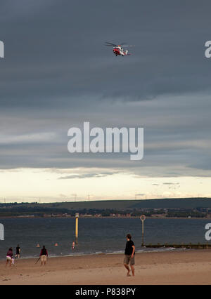 Edinburgh, Regno Unito. 08 luglio 2018. Portobello Beach, Edimburgo, Scozia, tra 7 pm e 9 pm di questa sera per la guardia costiera con quattro o più veicoli più un elicottero e una barca rinforzata conducendo una ricerca del litorale della spiaggia affollata, incidente sconosciuto Foto Stock