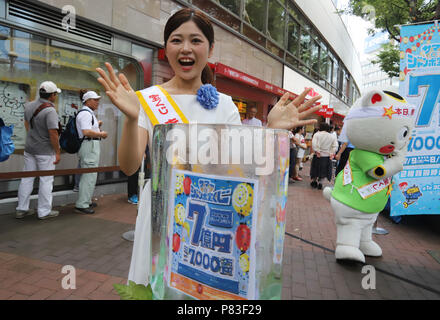 Tokyo, Giappone. 9 Luglio, 2018. Una lotteria ragazza di campagna Haruka Kusano sorrisi prima di un ticket booth per sette centinaia di milioni di yen (7 milioni di dollari) 'Summer Jumbo Lottery" come prima i biglietti vanno sulla vendita a Tokyo lunedì 9 luglio 2018. Migliaia di scommettitori in coda per i biglietti nella speranza di diventare un milionario in la lotteria annuale. Credito: Yoshio Tsunoda/AFLO/Alamy Live News Foto Stock