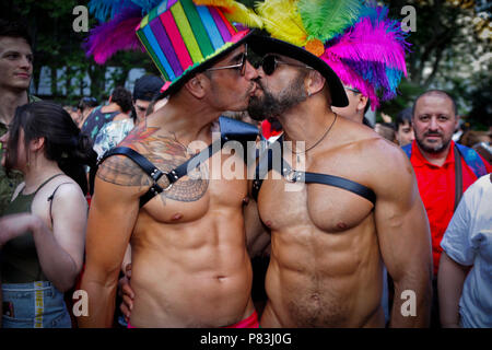 Coppia gay visto baciare ogni altro durante il 2018 Pride Parade. Migliaia di persone sono state riempiendo le strade e viali di Madrid in una giornata di sole per il 2018 Gay Pride Parade dopo ancora lottando per i diritti dei gay in tutto il mondo. Foto Stock