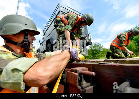 Podborany, Repubblica Ceca. 9 Luglio, 2018. Soldati ceca che stanno per entrare a far parte dei Baltici missione all interno della NATO rafforzata presenza in avanti (EFP) Missione in Lituania, caricare i loro veicoli militari sui carri a Podborany, Repubblica Ceca, lunedì 9 luglio 2018. Credito: Ondrej Hajek/CTK foto/Alamy Live News Foto Stock