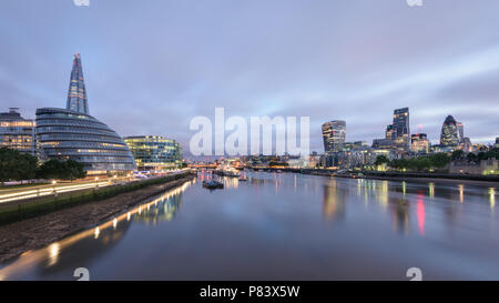 Vista dal Ponte della Torre di Londra London Bridge sul fiume Tamigi con la Shard, Municipio Gherkin, Cheesegrater e walkie talkie edifici all'alba Foto Stock