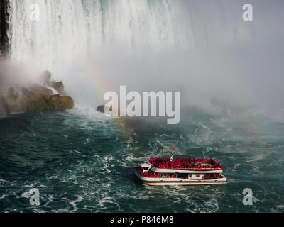 Hornblower piena di turisti di fronte American Falls, Niagara Falls, Canada su un cielo blu chiaro giorno con un arcobaleno Foto Stock
