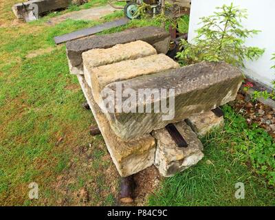 Cumulo di autentica soft macigni preparare per la ricostruzione della vecchia casa. Pila di pietra arenaria naturale mattone sul sito in costruzione Foto Stock