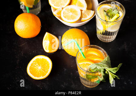 Fette di arance e di limoni in acqua detox Foto Stock
