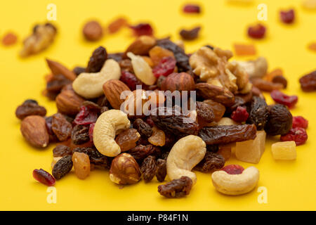 Chiusura del mix di frutta secca e i dadi su sfondo giallo Foto Stock