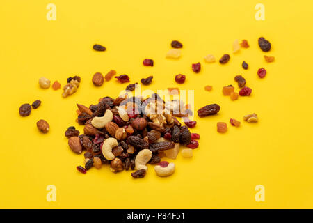 Mix di frutta secca e i dadi su sfondo giallo Foto Stock