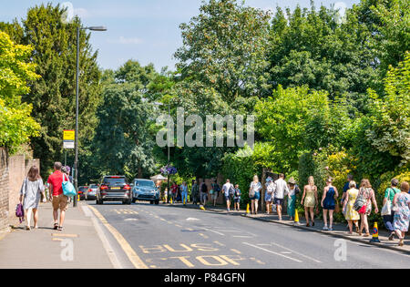 Lunga coda di persone camminando sul marciapiede per tutti England Lawn Tennis Championship in estate, Wimbledon, London, England, Regno Unito Foto Stock