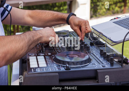 DJ mani sulle apparecchiature. Giradischi DJ Console mixer con controllo a due mani in concerto Foto Stock