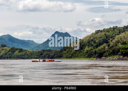 Un gruppo di giovani monaci buddisti navigare il Fiume Mekong con una barca dalla coda lunga a Luang Prabang, Laos Foto Stock