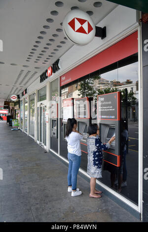 Un cliente utilizza il bancomat al di fuori della Banca filiale della HSBC a Notting Hill, Londra centrale. Foto Stock