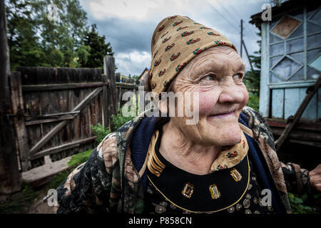 Una vecchia donna sorridente, in Kazakistan, davanti a casa sua. Foto Stock