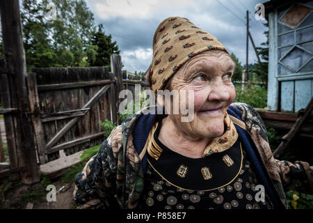 Una vecchia donna sorridente, in Kazakistan, davanti a casa sua. Foto Stock