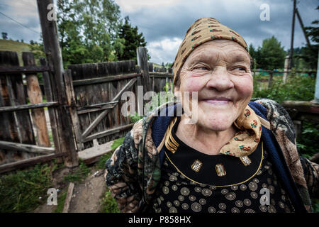 Una vecchia donna sorridente, in Kazakistan, davanti a casa sua. Foto Stock