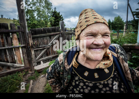 Una vecchia donna sorridente, in Kazakistan, davanti a casa sua. Foto Stock