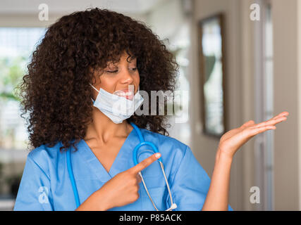 African American donna medico professionista molto felice puntando con mani e dita Foto Stock