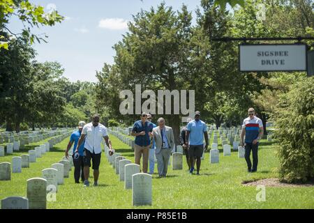 Asta Gainer (centro), storico, il Cimitero Nazionale di Arlington, conduce un tour con i membri della Detroit Lions accanto al montante del Maine nella sezione 23 di Al Cimitero Nazionale di Arlington Arlington, Virginia, 12 giugno 2018, 12 giugno 2018. I Lions hanno visitato il Cimitero Nazionale di Arlington per partecipare a un personale educativo ride dove hanno parlato con rappresentanti del cimitero, operazioni sul campo, ha ricevuto un tour del Memorial Anfiteatro Sala di visualizzazione da ANC storici, e guardato la cerimonia del Cambio della guardia presso la tomba del Milite Ignoto. (U.S. Foto dell'esercito da Elizabeth Fraser / Arlingto Foto Stock