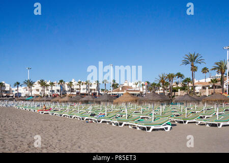 Sedie a sdraio e ombrelloni in spiaggia di Benalmadena, Costa del Sol, Spagna Foto Stock