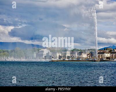 Guardando attraverso il lago di Ginevra attraverso lo spruzzo del getto d-Eau, verso l'inizio delle alpi. Ginevra, Svizzera. Foto Stock