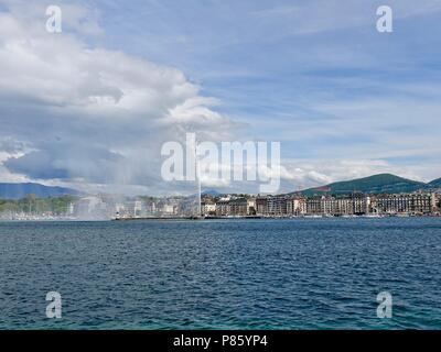 Guardando attraverso il lago di Ginevra attraverso lo spruzzo del getto d-Eau, verso l'inizio delle alpi. Ginevra, Svizzera. Foto Stock