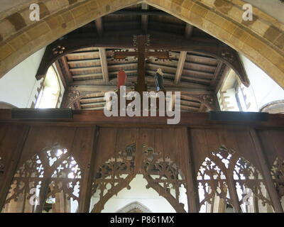 Una vista guardando indietro attraverso il XV secolo rood screen dal coro alla navata centrale all'interno della chiesa sassone, tutti i Santi, a Earls Barton Foto Stock