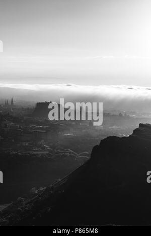 Silhouette di Salisbury Craigs ad Edimburgo, Scozia, poco prima del tramonto. Foto Stock