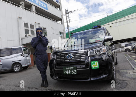 9 luglio 2018 - Yokohama, Giappone - un tassista vestito in costume Ninja in posa per una fotografia accanto al suo esterno cabina Sanwa Koutsu gruppo compagnia di taxi a Yokohama. Yokohama basata su provider taxi Sanwa Koutsu Group ha lanciato un nuovo servizio chiamato ''Ninja de Taxi'' per attirare gli enti locali e i clienti esteri. Il ninja costume cab driver forniscono un esperienza unica per i clienti, mostrando la loro abilità ninja, quali passi veloci e i segni delle dita. Il ninja taxi service è avviato a partire dalla metà di giugno e può essere prenotato sul loro sito web (disponibile in Inglese, Cinese e Giapponese) con un costo aggiuntivo (1.000 JPY Foto Stock