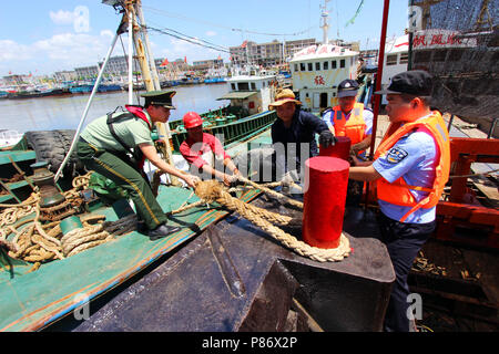 Taizhou, cinese della Provincia di Zhejiang. 10 Luglio, 2018. Poliziotti e soldati aiutare i pescatori ormeggiare barche da pesca in Taizhou, est della Cina di Provincia dello Zhejiang, 10 luglio 2018. China Meteorological Administration martedì rilasciato quest'anno il primo red alert per il Typhoon come il tifone Maria o 8 l'anno si avvicina alla costa cinese. Typhoon Maria è probabile per spazzare Taiwan, Fujian, Jiangxi e parte della provincia del Zhejiang il martedì e il mercoledì. Credito: Jiang Youqin/Xinhua/Alamy Live News Foto Stock