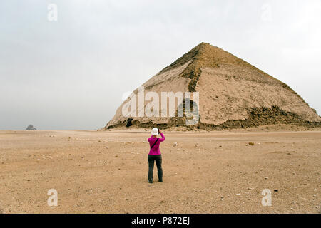 Un turista fotografie piegato la piramide a Dahshur, costruita per il Faraone Sneferu, Governatorato di Giza in Egitto. Foto Stock